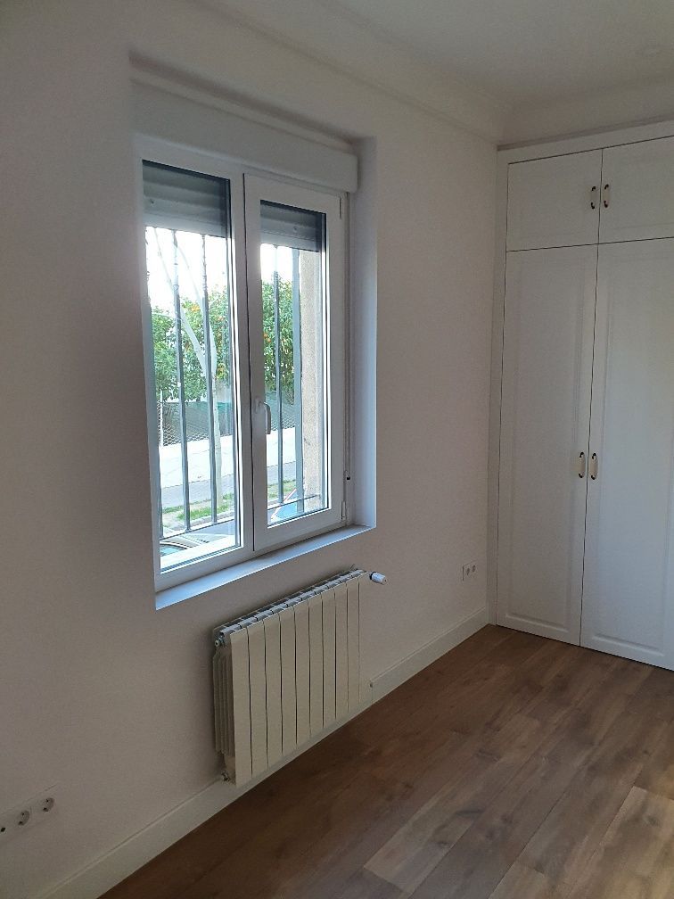 Una habitación vacía con un radiador y una ventana.