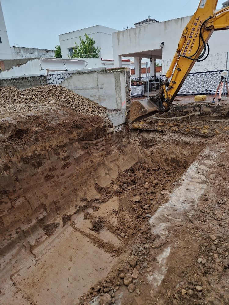 Una excavadora amarilla está cavando un hoyo en el suelo.