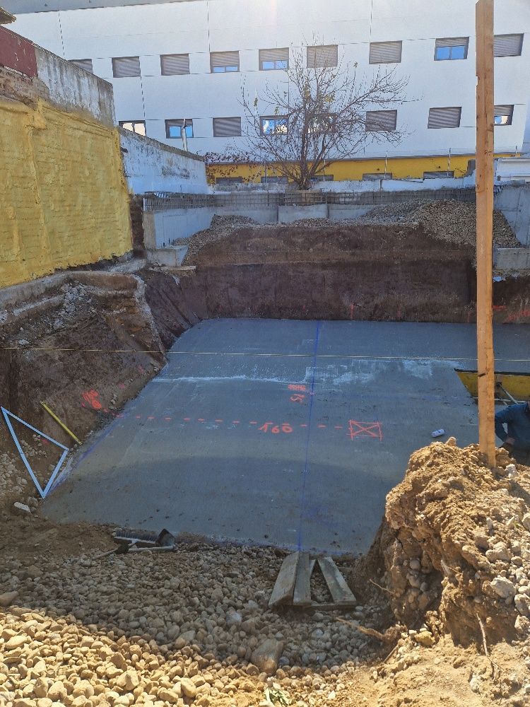 Un gran agujero en el suelo con un edificio al fondo.