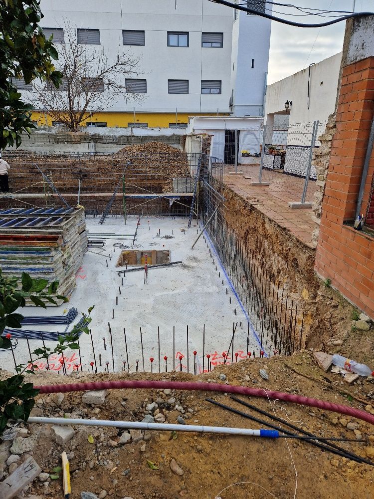 Un sitio de construcción con un gran edificio al fondo.