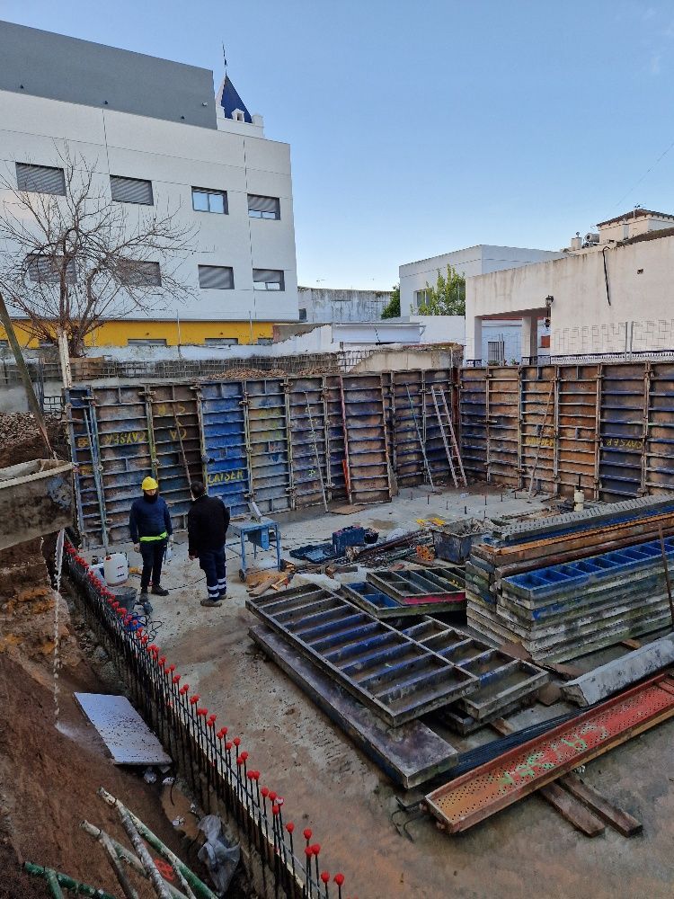 Un sitio de construcción con un gran edificio al fondo.