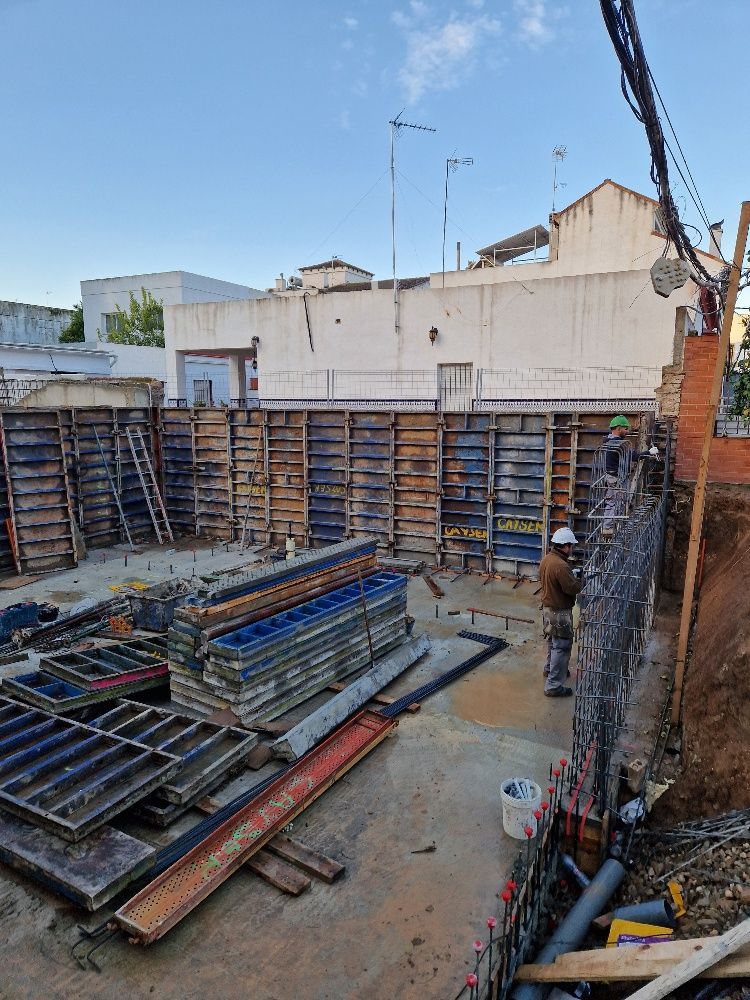 Una obra en construcción con muchos andamios de madera y una grúa.