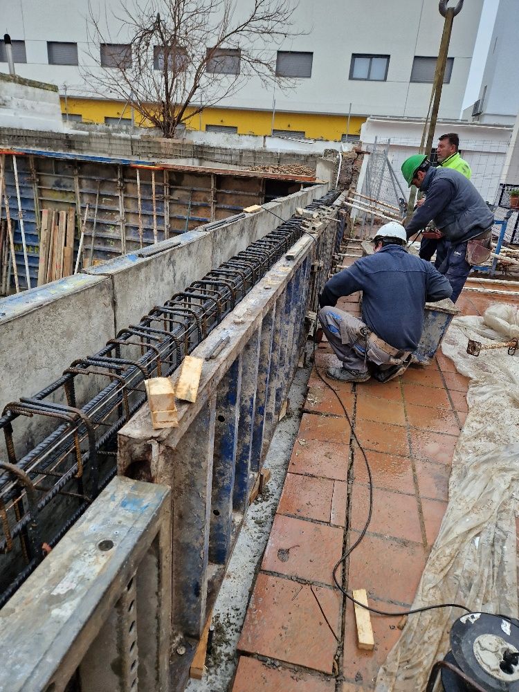 Un grupo de trabajadores de la construcción está trabajando en un edificio en construcción.