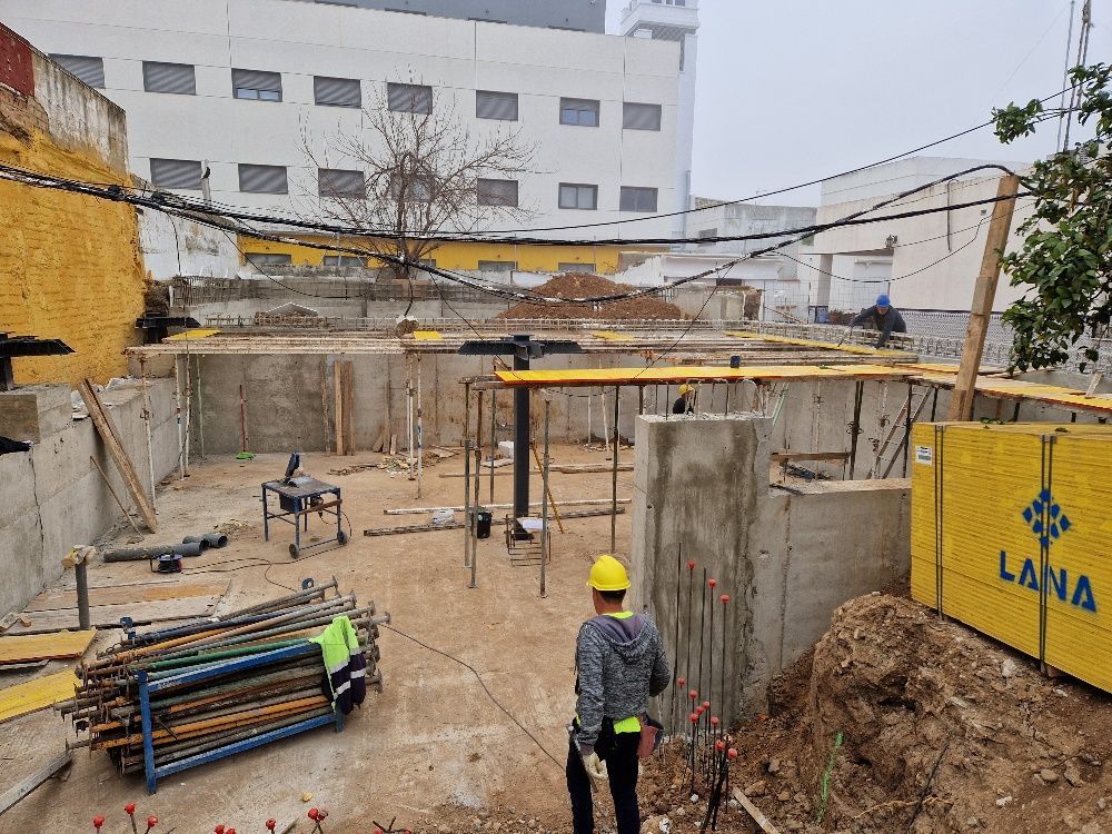 Un hombre con casco está parado en un sitio de construcción.