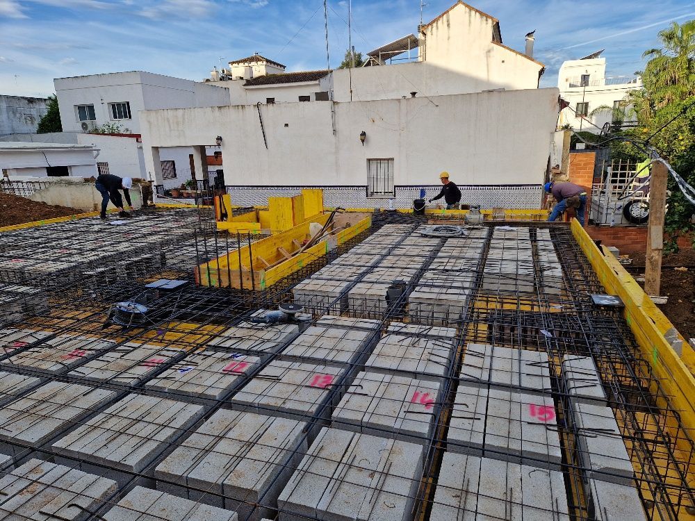 Una obra en construcción con muchos bloques de hormigón y un edificio al fondo.