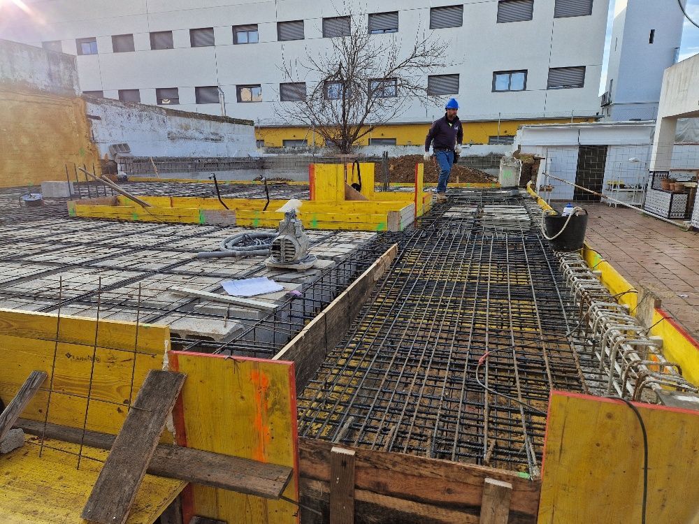 Un hombre está parado en un sitio de construcción al lado de un edificio.
