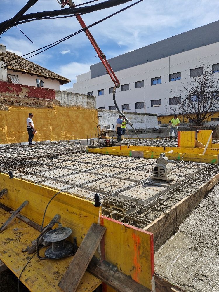 Un sitio de construcción con un gran edificio al fondo.