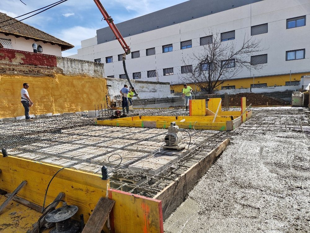 Un sitio de construcción con un gran edificio al fondo.