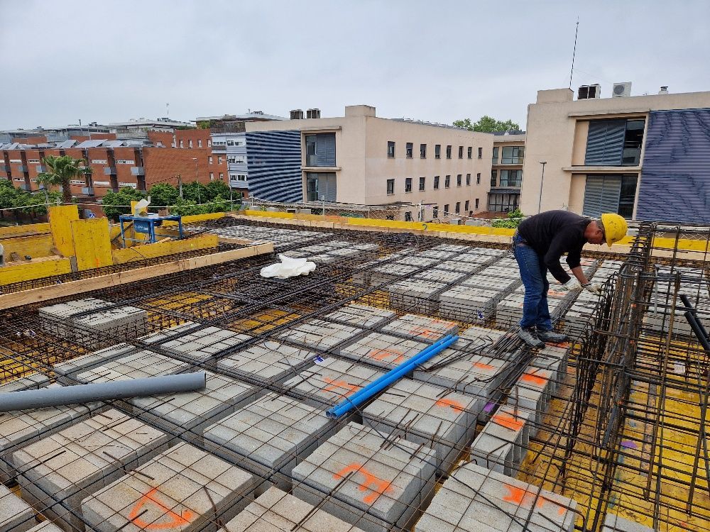 Un trabajador de la construcción está trabajando en el tejado de un edificio.