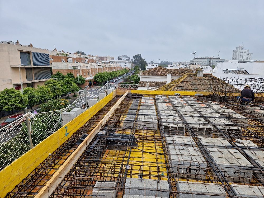 Un hombre está sentado en el tejado de un edificio en construcción.