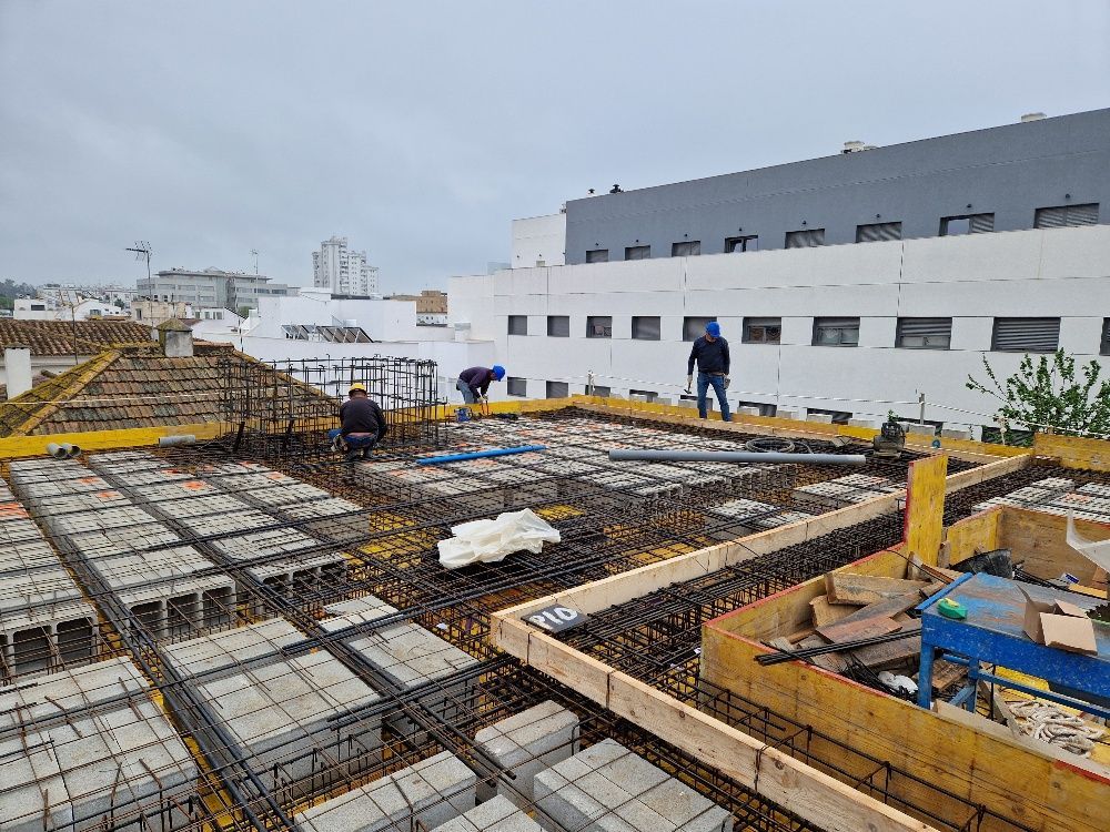 Un grupo de hombres está trabajando en un sitio de construcción frente a un edificio.