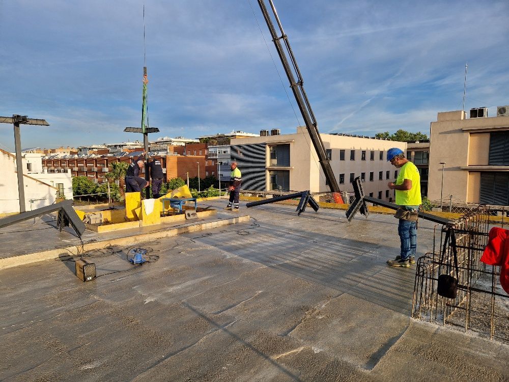 Un grupo de trabajadores de la construcción está trabajando en el techo de un edificio.