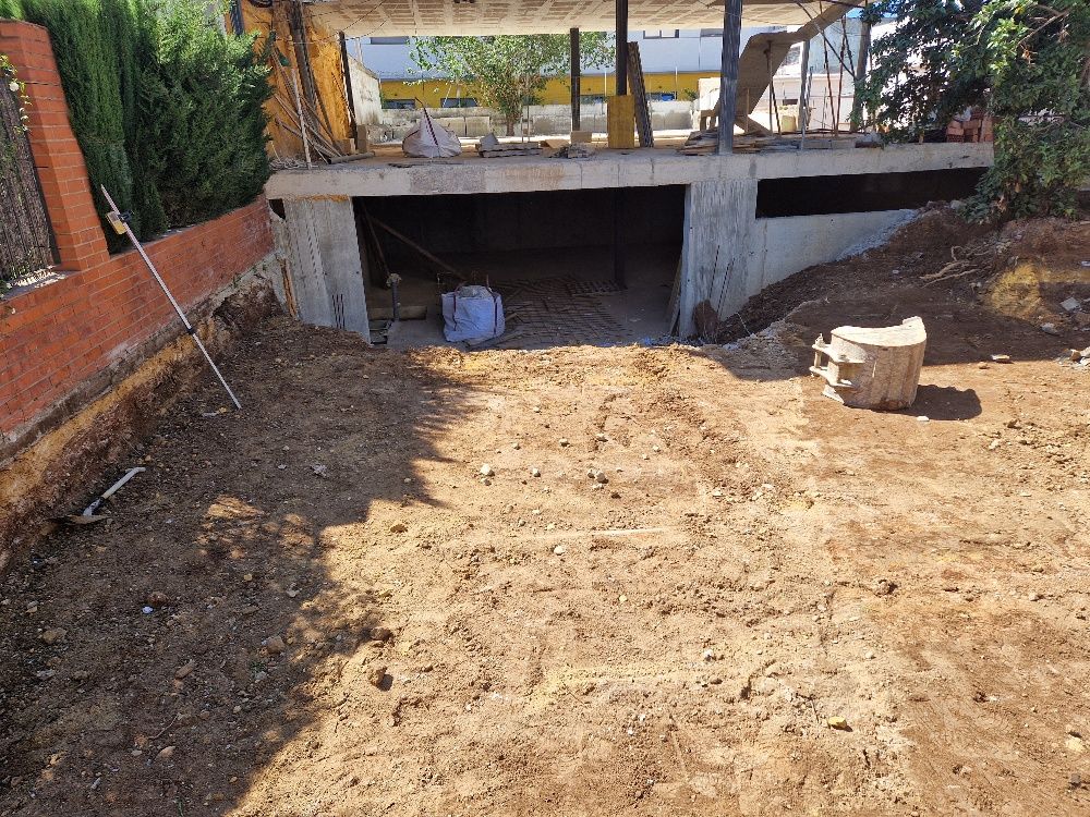 Un gran montón de tierra se encuentra frente a un edificio en construcción.