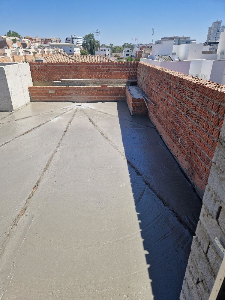 Una pared de ladrillos rodea una pasarela de hormigón en el tejado de un edificio.