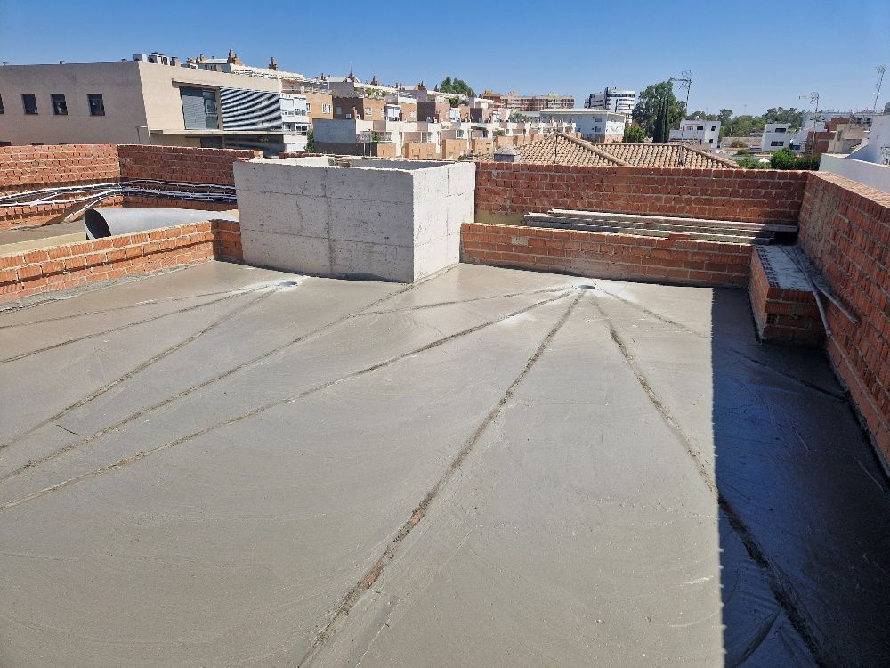 Una azotea con una pared de ladrillo y un piso de concreto