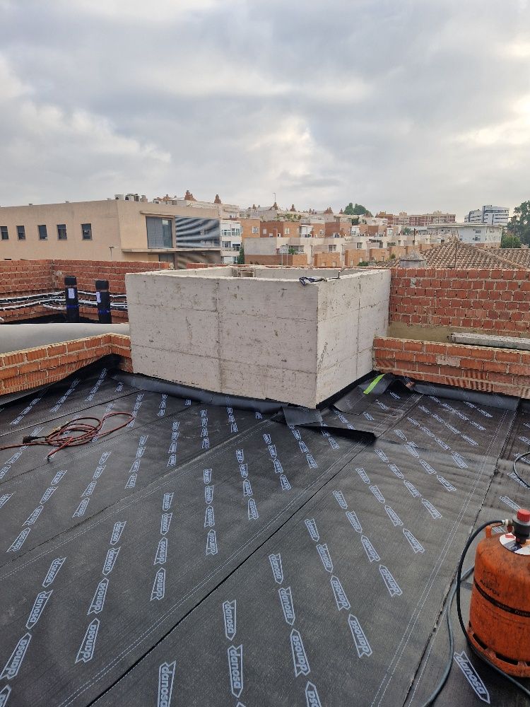 Un cilindro de gas está sobre el techo de un edificio en construcción.