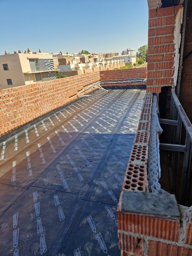 Se está construyendo un balcón encima de un edificio de ladrillo.