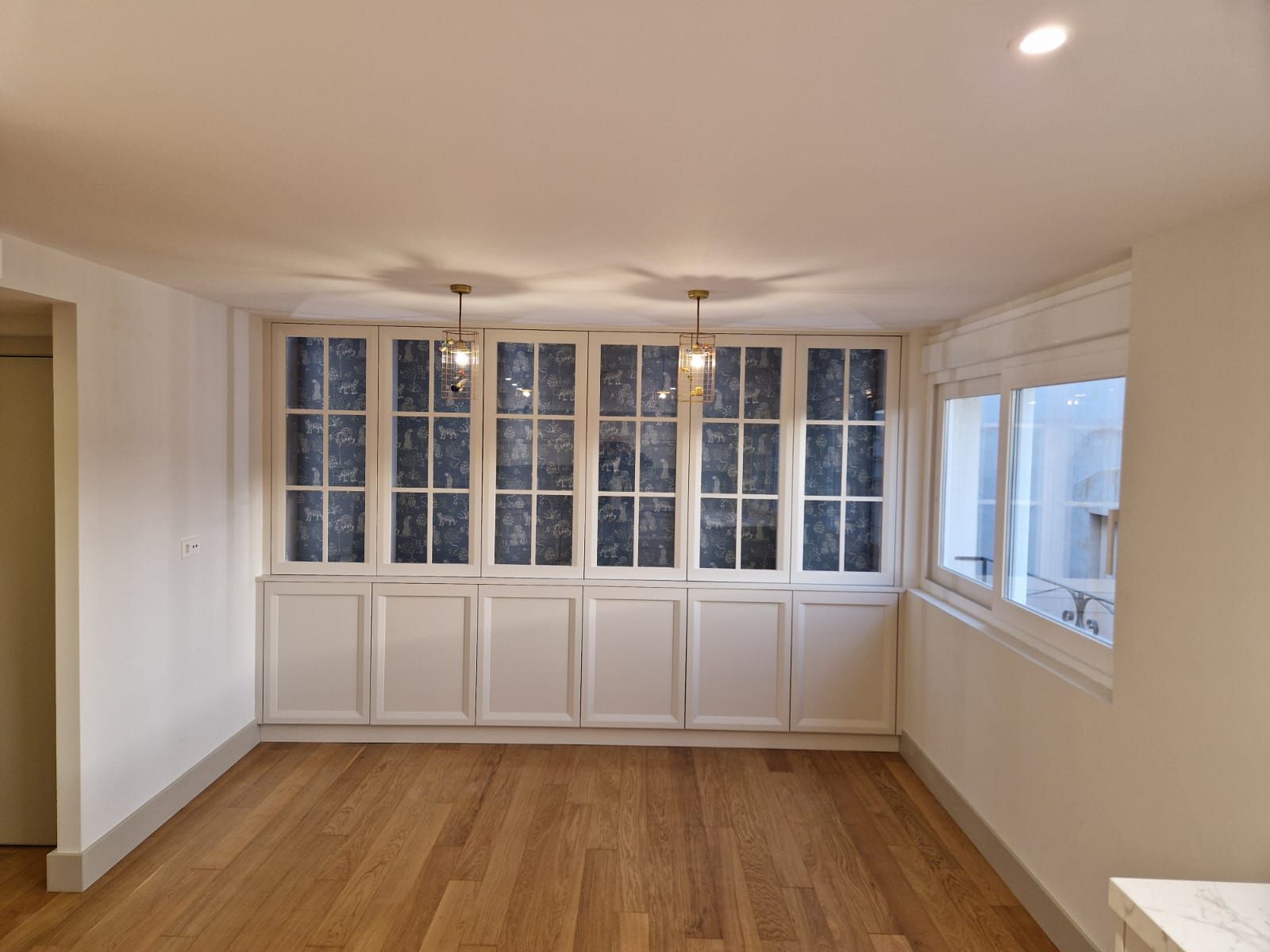 Una habitación vacía con muchas ventanas y armarios.