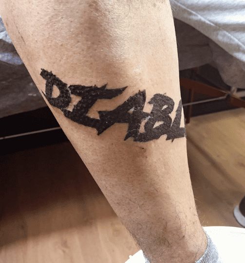 Tatuaje negro en el brazo de una persona que dice 