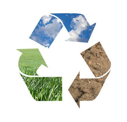 Un símbolo de reciclaje con césped y tierra.