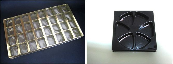 Una bandeja dorada y una bandeja negra están sobre una mesa.