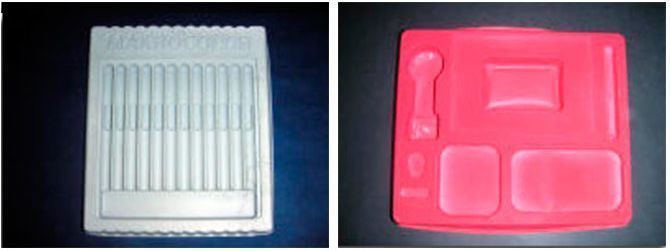 Una bandeja blanca y una bandeja roja sobre una mesa.