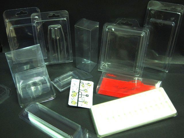 Un montón de cajas de plástico transparente están sobre una mesa.