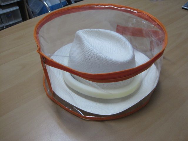 Un sombrero blanco está en una bolsa de plástico transparente.