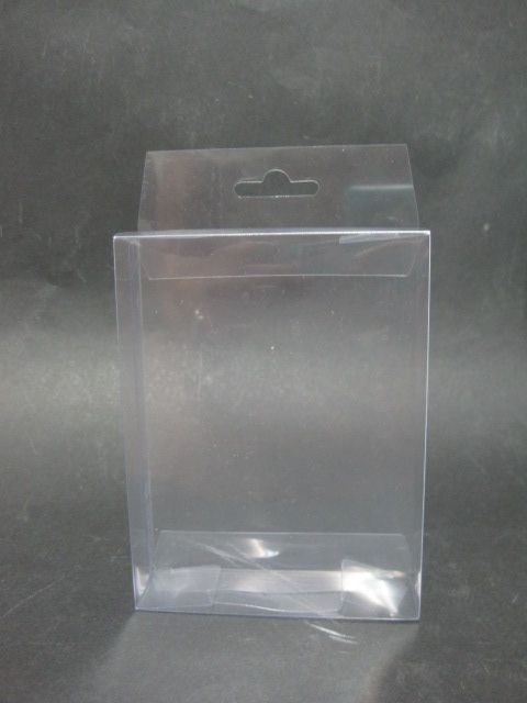 Una caja de plástico transparente con un gancho en el costado está sobre una mesa.