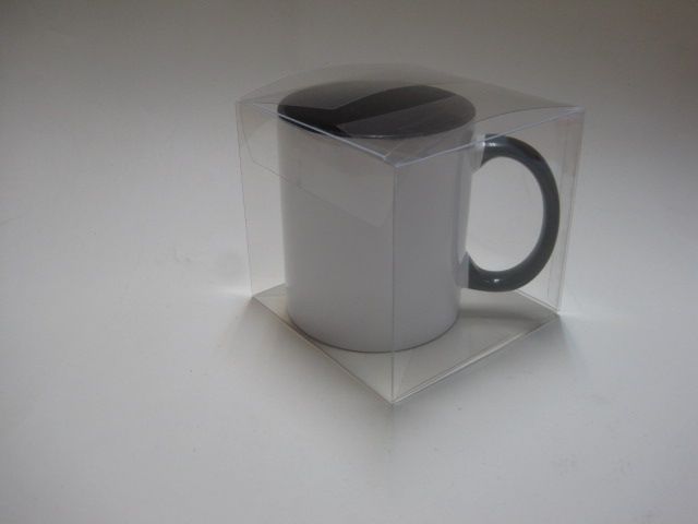 Una taza de café blanca en una caja de plástico transparente