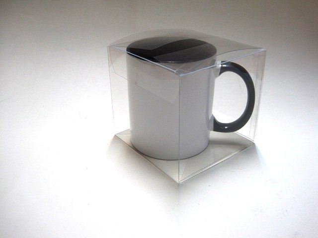 Una taza de café blanca en una caja de plástico transparente