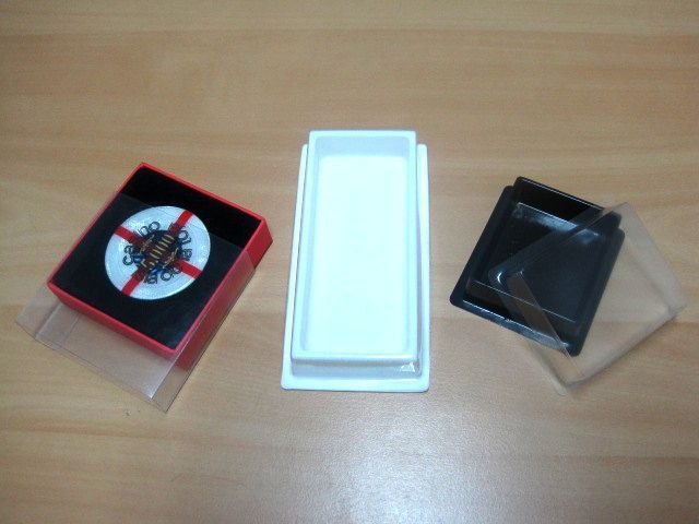 Una caja roja con una cruz roja se encuentra al lado de una caja blanca y una caja negra.