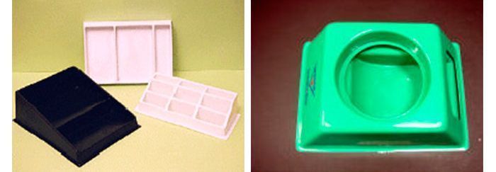 Un recipiente de plástico verde y uno rosa están uno al lado del otro sobre una mesa.