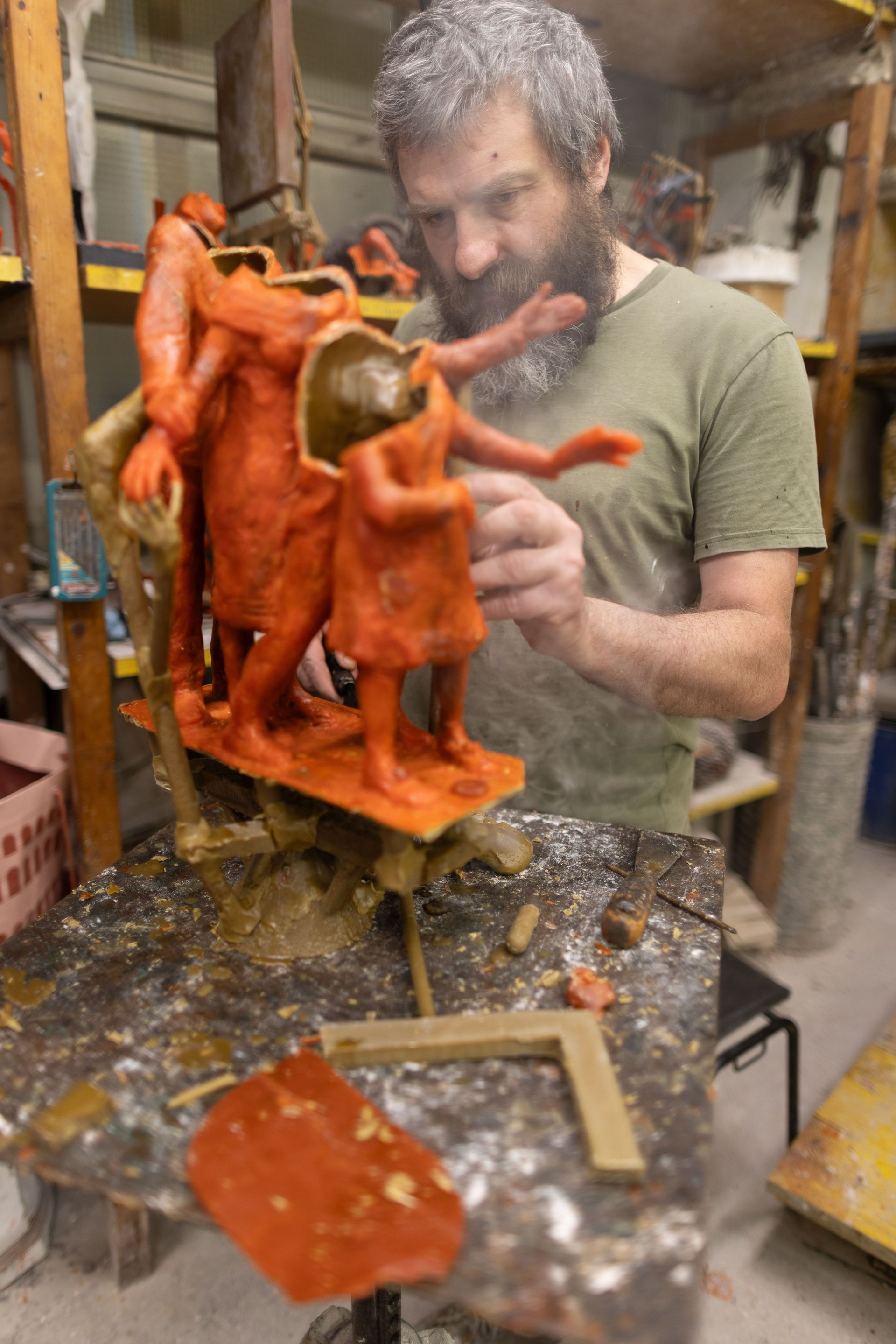 Un uomo sta lavorando a una scultura in uno studio.