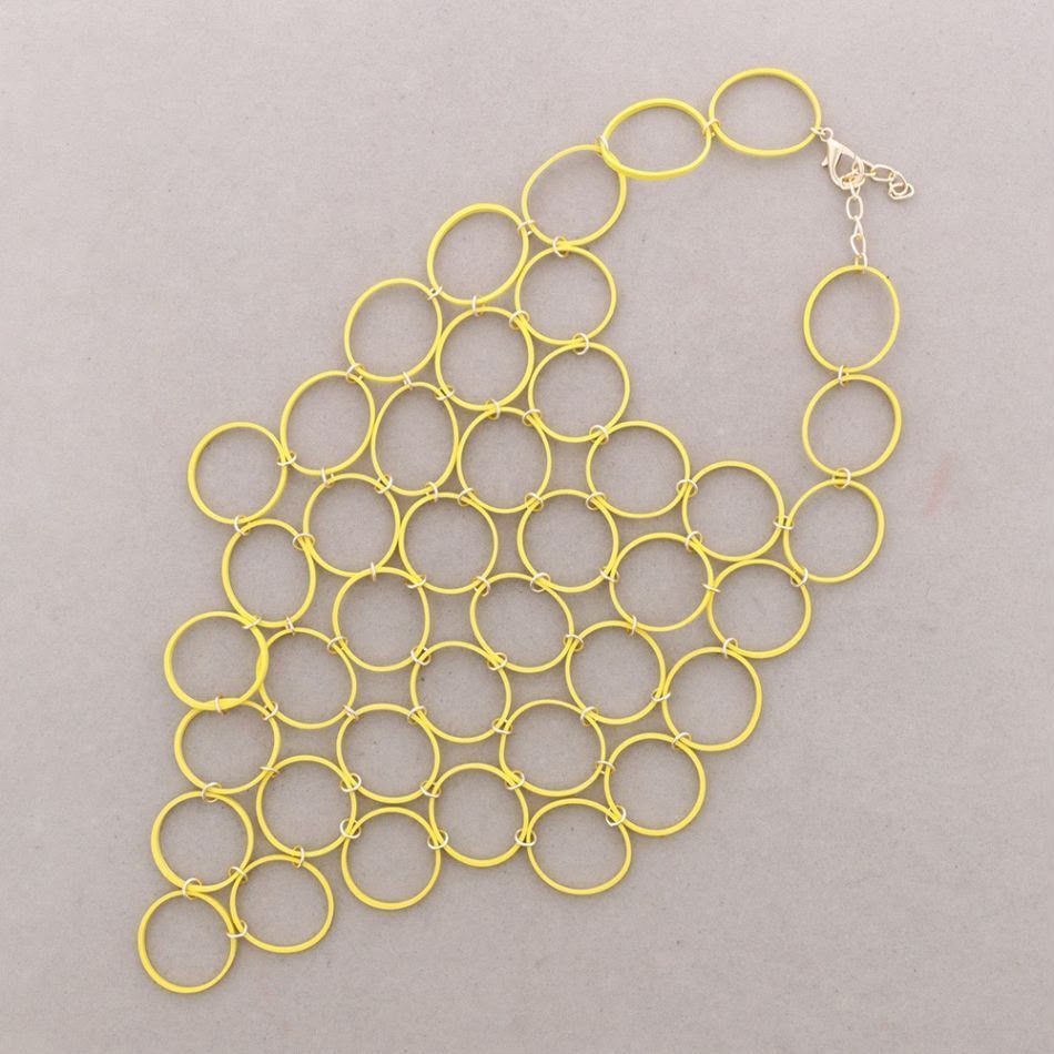 Collar con cadena de aro de metal amarillo sobre fondo claro.