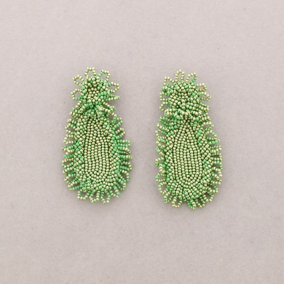 Par de pendientes verdes con forma de piña y cuentas sobre un fondo beige claro.
