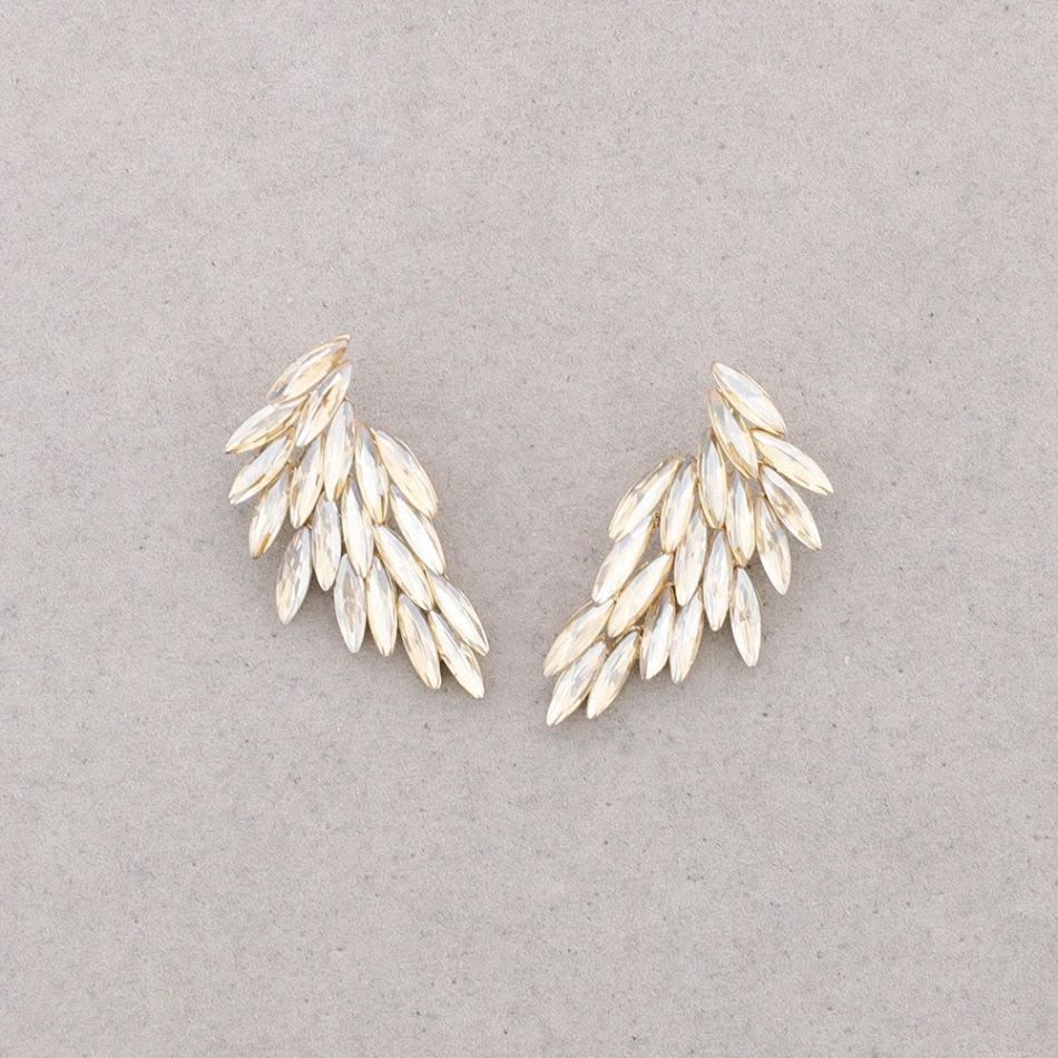 Dos pequeños adornos blancos en forma de hoja dispuestos como alas sobre un fondo gris.