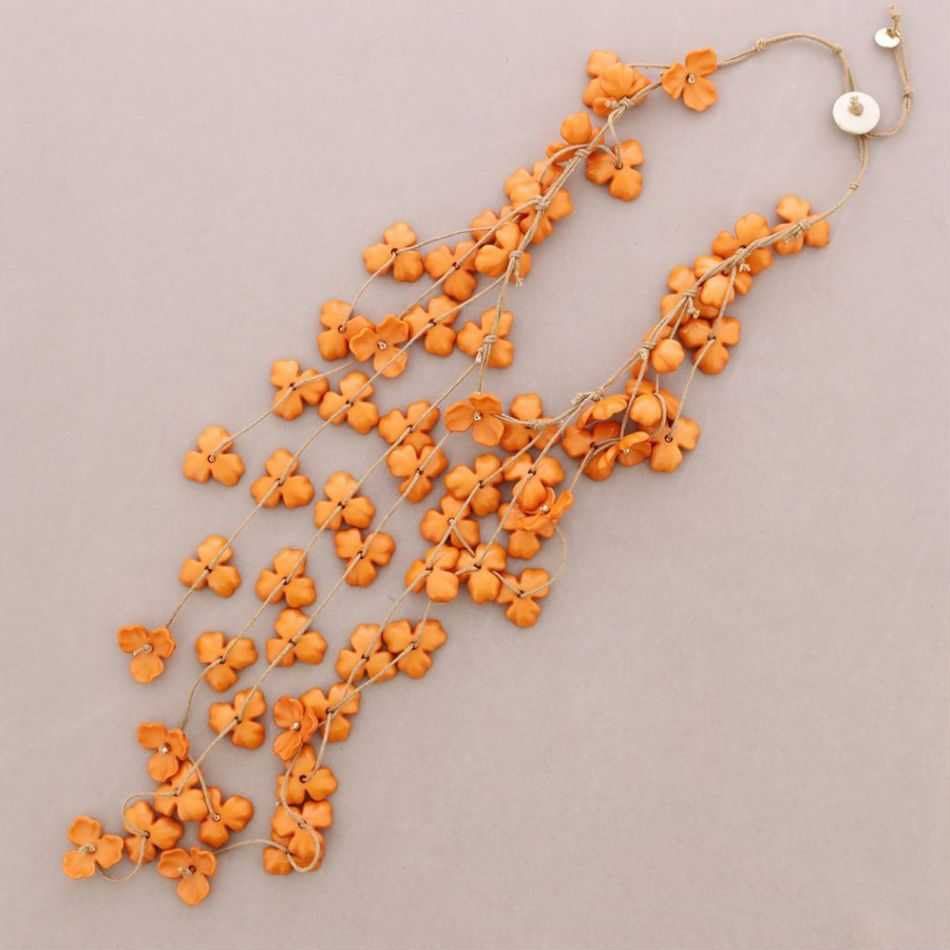 Collar floral naranja sobre fondo beige