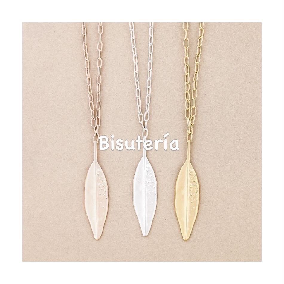 Tres collares colgantes con forma de hoja en oro rosa, plata y oro sobre un fondo beige.