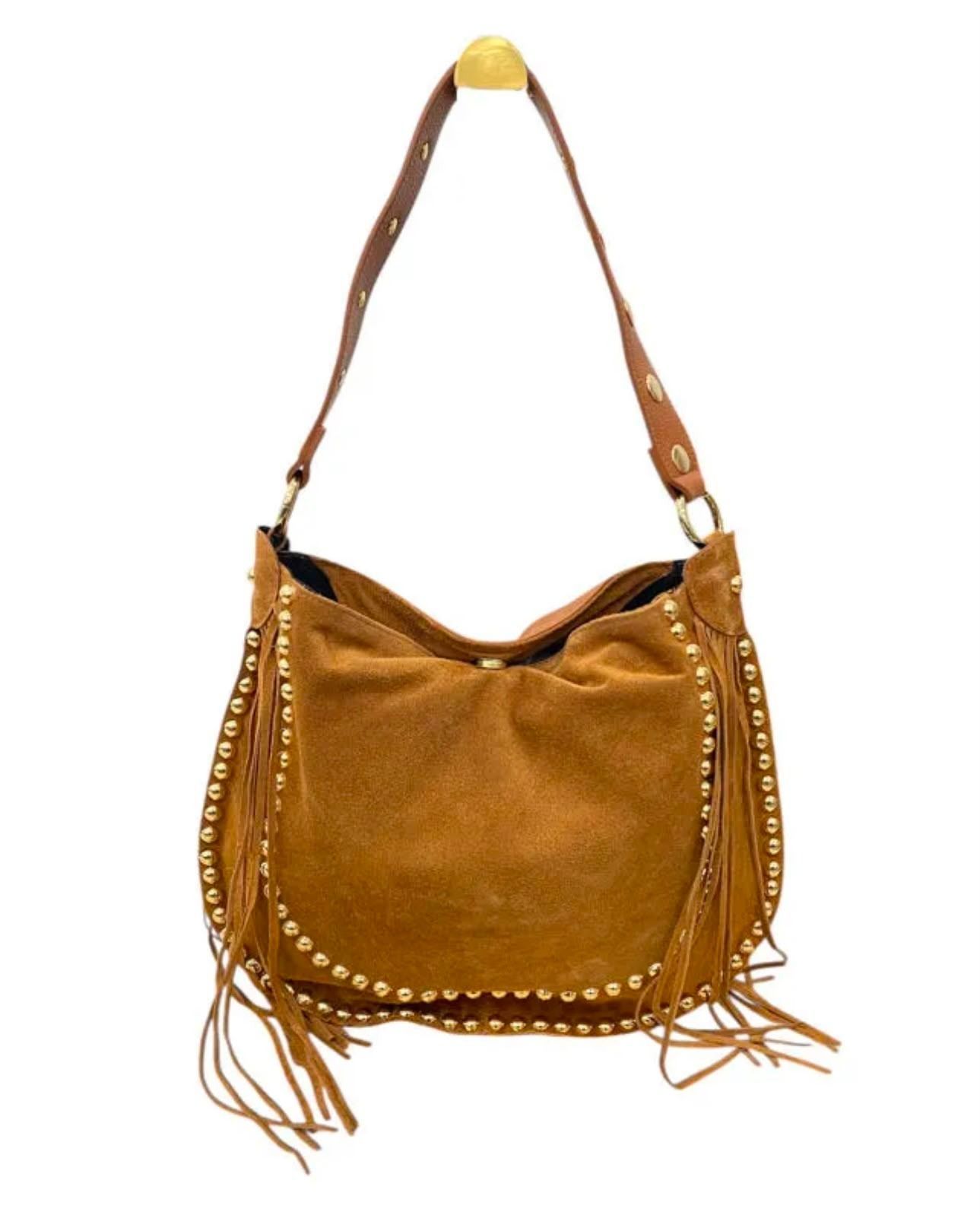 Bolso de hombro de ante color camel con flecos y detalles de tachuelas doradas sobre fondo blanco.