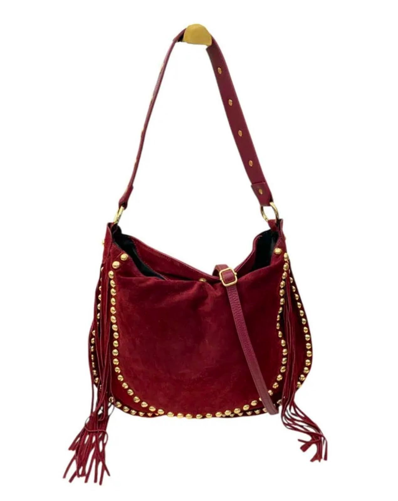 Bolso de hombro de ante color burdeos con tachuelas doradas y borlas de flecos sobre fondo blanco.
