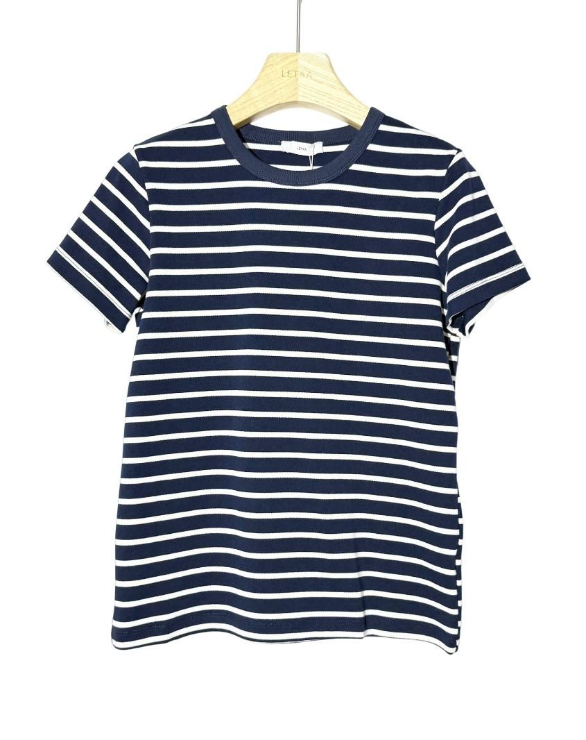 Camiseta de manga corta a rayas azul marino y blancas colgada en una percha.