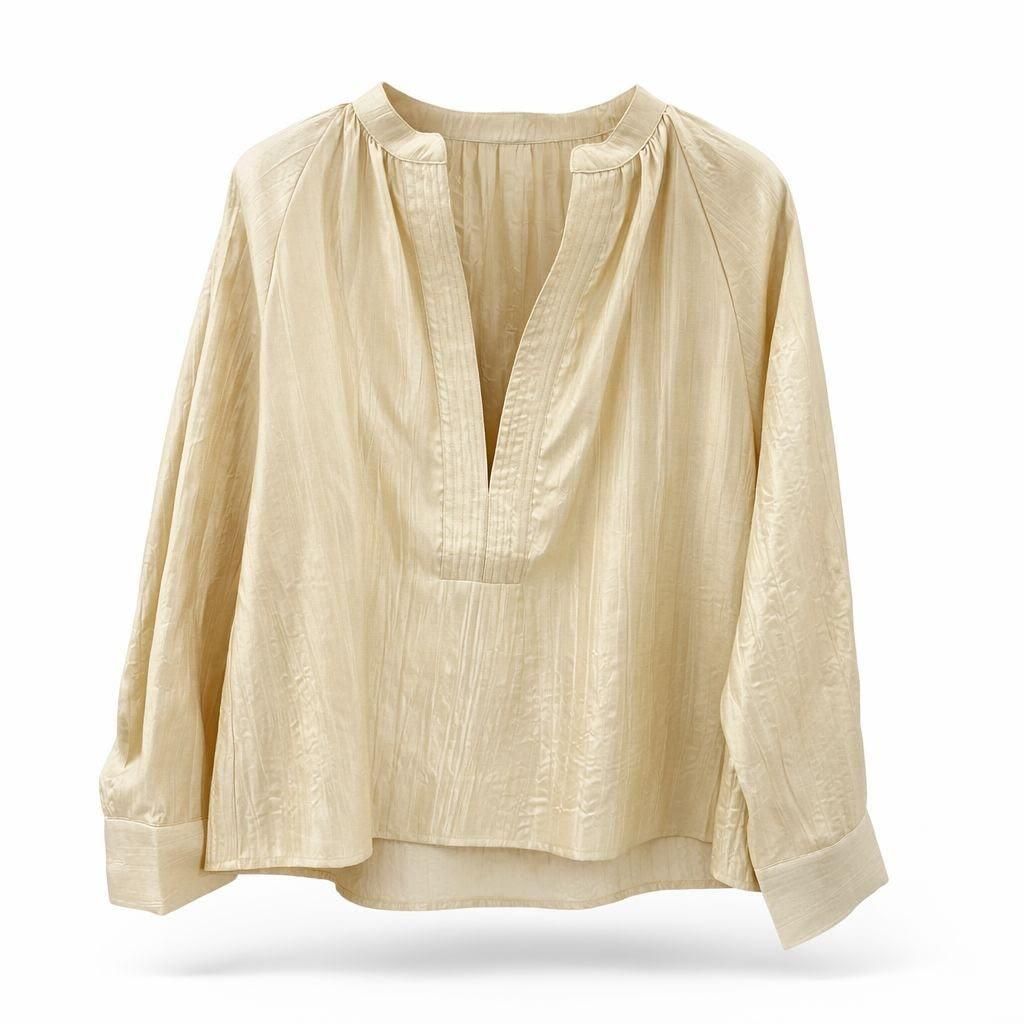 Blusa color crema de manga larga con escote en V pronunciado y corte holgado sobre fondo blanco.