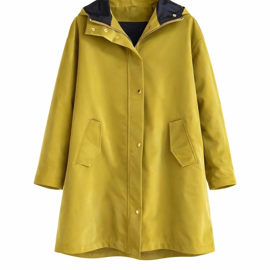 Impermeable amarillo con capucha, forro negro y bolsillos delanteros, colgado sobre un fondo blanco.
