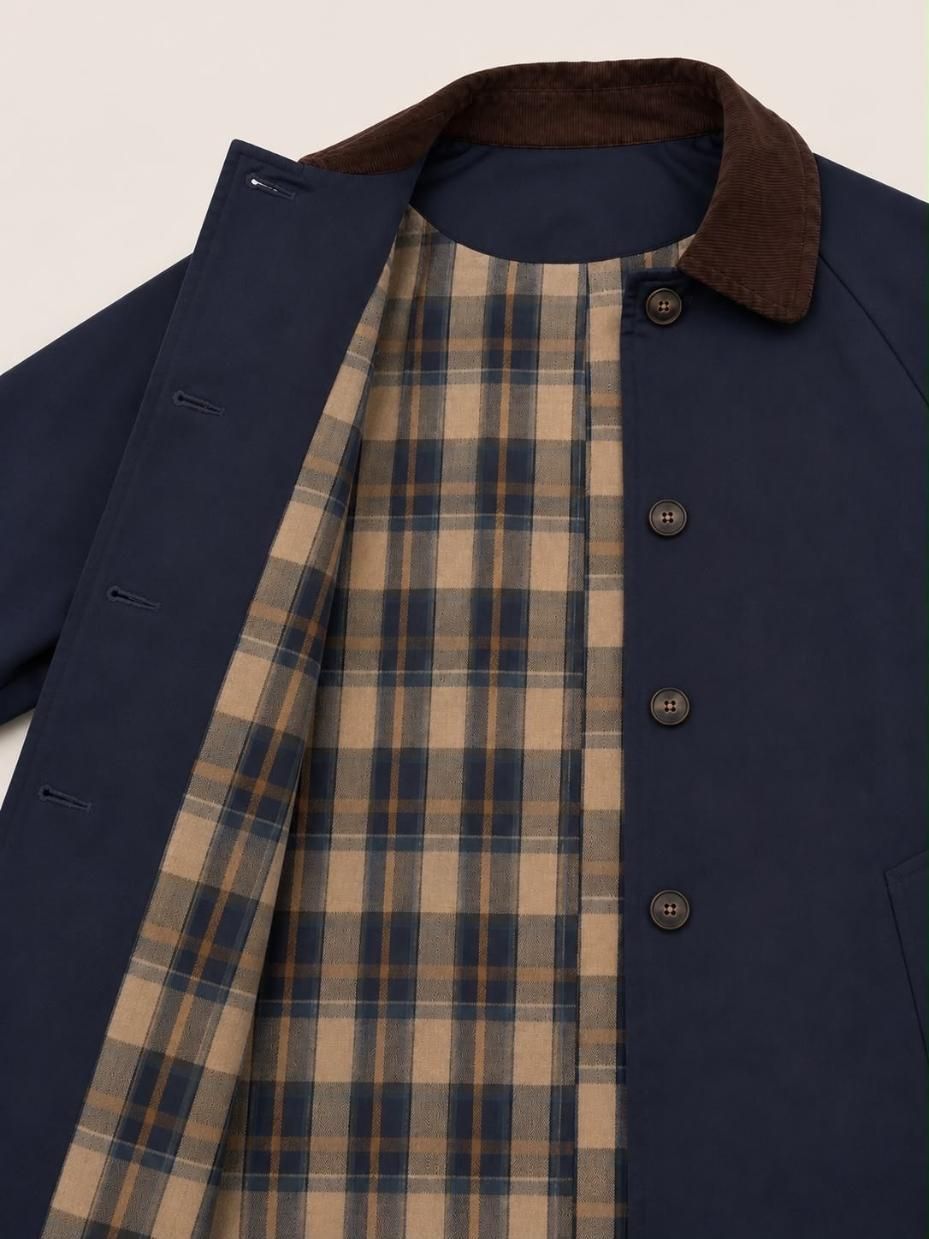 Chaqueta azul marino con cuello de pana marrón, forro a cuadros y cierre de botones delanteros.