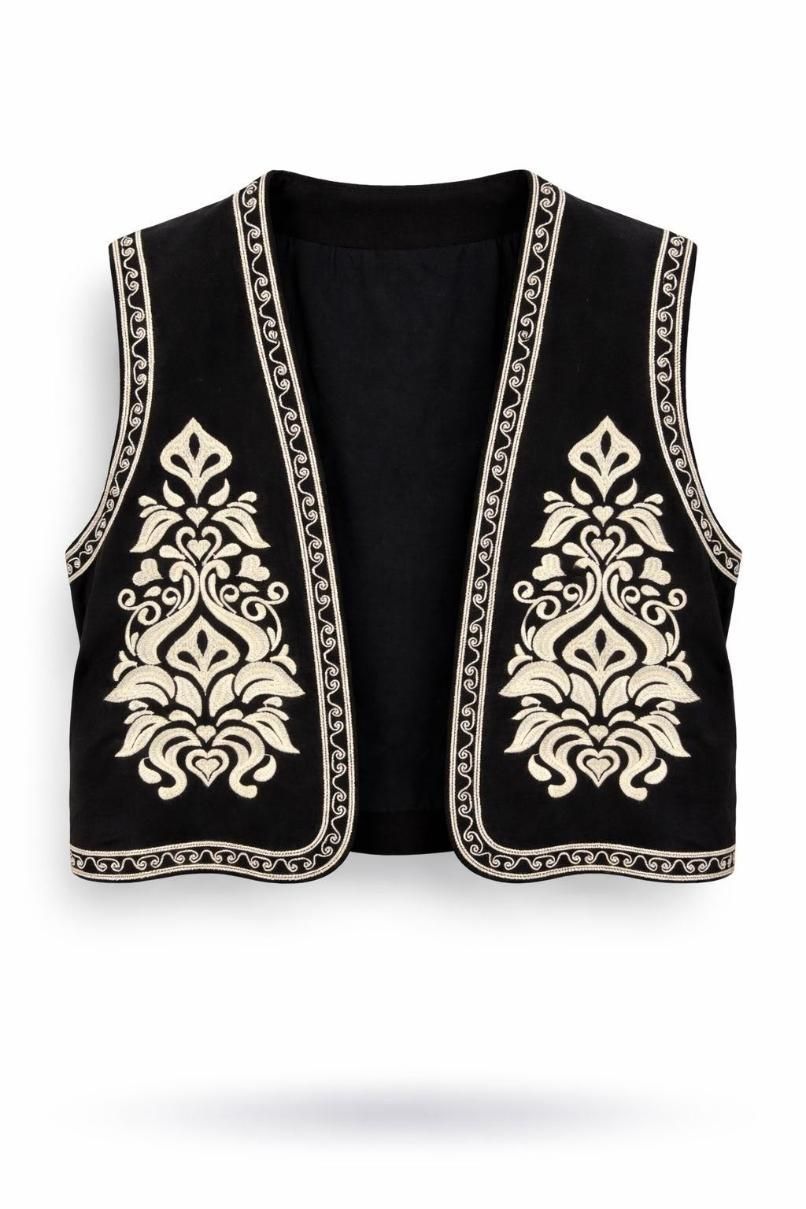 Chaleco negro sin mangas bordado con ribete floral blanco sobre fondo blanco