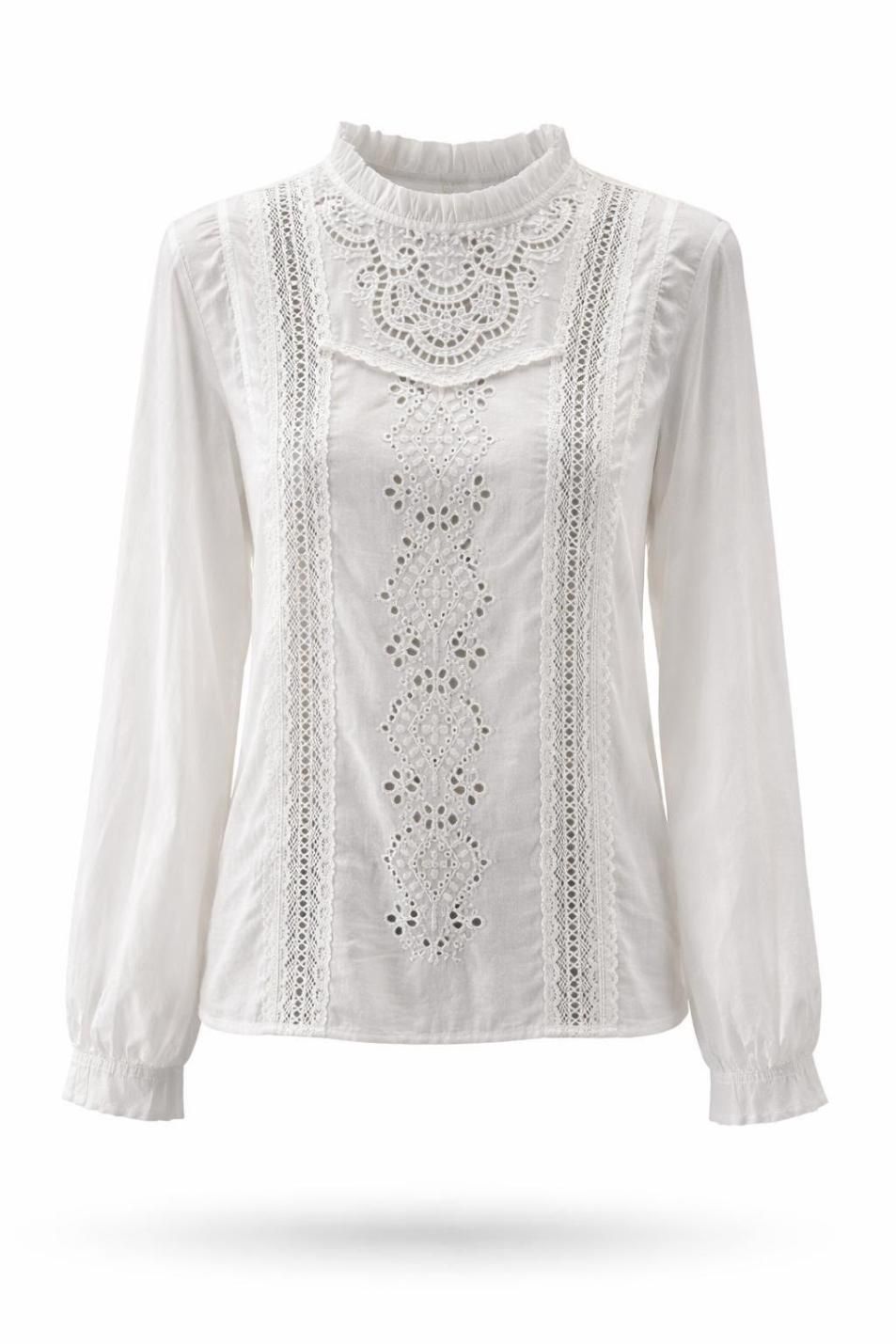Blusa blanca de encaje de manga larga con cuello alto y detalles de volantes sobre fondo liso.