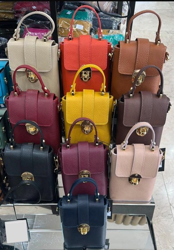 Exhibición de coloridos bolsos apilados en estantes en una tienda.