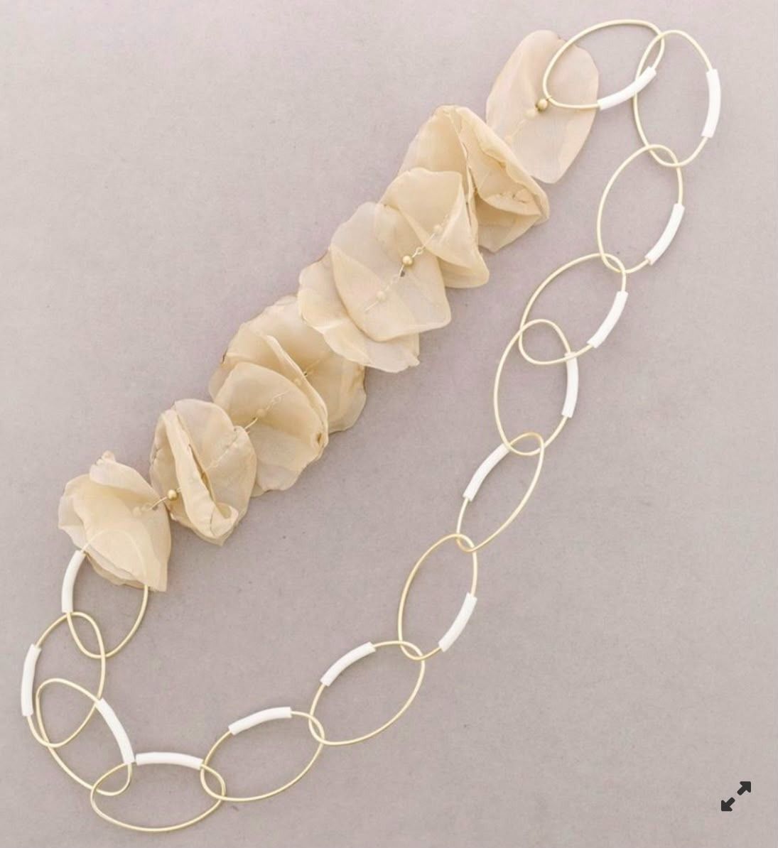 Collar de oro con eslabones de cadena ovalados y una hilera de cuentas de color crema pálido con forma de concha.