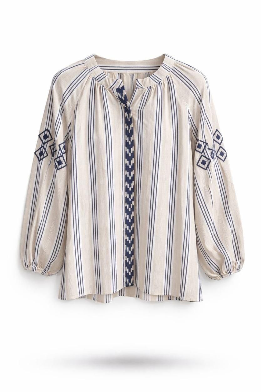 Blusa de manga larga bordada a rayas color crema con escote con lazo de borla y detalles geométricos azules.